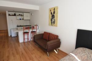sala de estar con silla y cocina en Roca 771 Apartment en Buenos Aires