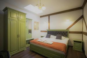 a bedroom with a large bed with green cabinets at La Curtea Domneasca in Piatra Neamţ +13 photos