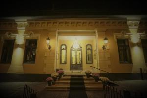 a building with stairs leading to the front door at La Curtea Domneasca in Piatra Neamţ