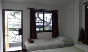 two beds in a room with a window at Aunt & Uncle's House in Chiang Mai +19 photos