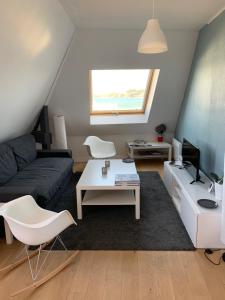 uma sala de estar com um sofá e uma mesa em Appartement Design II - Port du Rosmeur -Douarnenez em Douarnenez