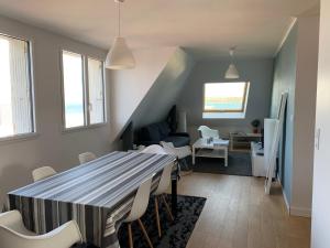 a dining room and living room with a table and chairs at Appartement Design II - Port du Rosmeur -Douarnenez in Douarnenez