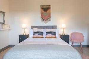 a bedroom with a large bed with two lamps at Duneden Cottage and Grounds in Randalstown