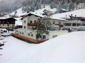 a group of buildings on a snow covered slope at St. Lukas Apartments in See