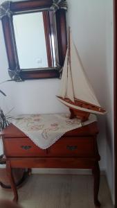 un pequeño barco de madera en un tocador con espejo en Christina Pansion, en Kokkari