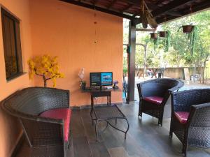 eine Terrasse mit Stühlen und einem Tisch mit einem Computer in der Unterkunft Hostel A Cozinha de Cora in Brasilia