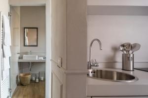 a kitchen with a stainless steel sink and a bathroom at Suites Menaggio in Menaggio +37 photos