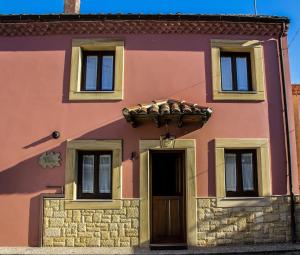 un edificio rosa con puerta y ventanas en Alto el Monte 1 - AR1414 en Luanco