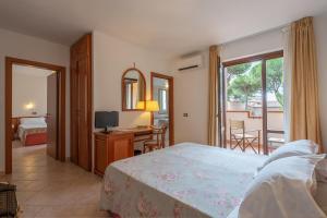 Dormitorio con cama, escritorio y TV en Ricci Hotel, en Marina di Grosseto