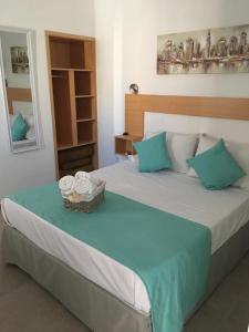 1 dormitorio con 1 cama y una cesta de toallas en Hotel Danae, en Piriápolis