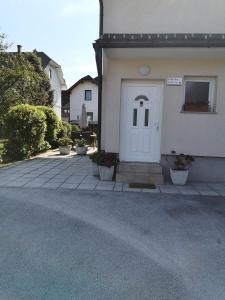 a white door on a white house with plants at Apartment Damijan in Bled