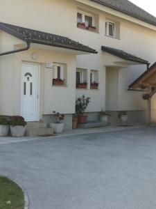 un bâtiment avec une porte blanche et des plantes en pot dans l'établissement Apartment Damijan, à Bled