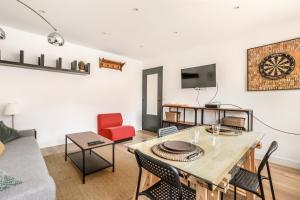 uma sala de estar com uma mesa e um sofá em Appartement Croisé Laroche 40m2 em Marcq-en-Baroeul