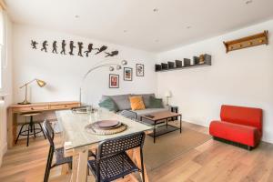 uma sala de estar com uma mesa e um sofá em Appartement Croisé Laroche 40m2 em Marcq-en-Baroeul