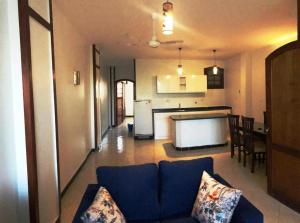 a living room with a blue couch and a kitchen at White House Apartments in Luxor