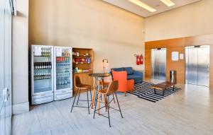 ein Restaurant mit einer Bar mit orangefarbenen Stühlen und einem Kühlschrank in der Unterkunft Go Inn Serra in Serra