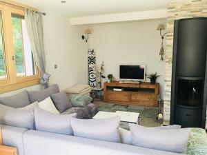 sala de estar con sofá y TV en L'Eterlou, 2 minutes à pied des télécabines, Paradiski, Belle vue, en Champagny-en-Vanoise