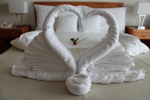 
a white towel laying on top of a white bed at Hôtel Bristol in Montreux
