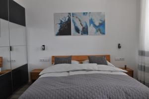 a bedroom with a large bed and a painting on the wall at Apartman Benjo in Hermagor