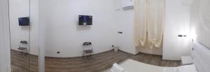 een kamer met witte muren en een houten vloer bij SOLE E LUNA in Taranto