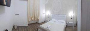 een witte slaapkamer met een wit bed en een spiegel bij SOLE E LUNA in Taranto