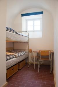 a bedroom with a bunk bed and a table and a desk at Stadthotel - Das alte Gefängnis in Braunau am Inn