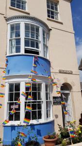 a building with colorful flags on the side of it at Olivers Guest House in Weymouth