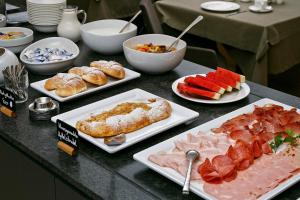 a table with different types of food on plates at Pension Pichler in Tirolo +10 photos