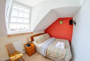 um quarto com uma cama com uma parede vermelha em Olivers Guest House em Weymouth