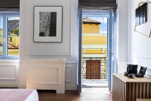 雅典A77 Suites, Small Luxury Hotels of the World的卧室设有通往阳台的门