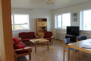 a living room with chairs and a table and a tv at The Nest in Raufarhöfn