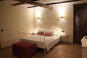 a bedroom with a white bed with pink pillows at Casa Rural Castil de Cabras in San Miguel de Valero