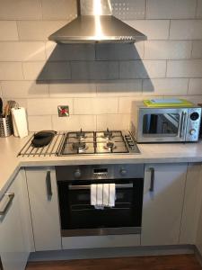 a kitchen with a stove and a microwave at 2 Crown Barton in Glastonbury +22 photos