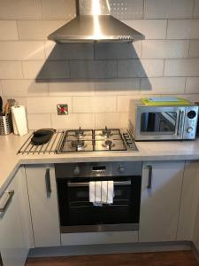 a kitchen with a stove and a microwave at 2 Crown Barton in Glastonbury