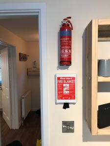 a fire extinguisher sign on a wall next to a door at 2 Crown Barton in Glastonbury