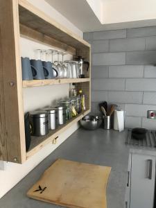 una cocina con armarios de madera con ollas y sartenes en 2 Crown Barton, en Glastonbury