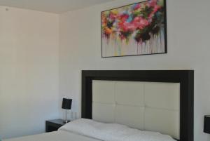 1 dormitorio con 1 cama y una pintura en la pared en Parque Inn Hotel & Suites en Coatzacoalcos