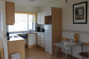 a kitchen with a white refrigerator and a table at The Nest in Raufarhöfn