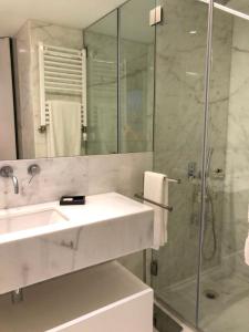 a white bathroom with a sink and a shower at Oporto Chic&Cozy - Ateneu in Porto