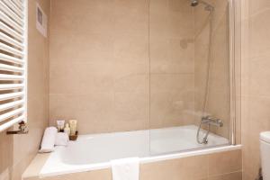 巴塞隆納的住宿－埃桑普勒易眠公寓，设有带浴缸和淋浴的浴室。