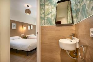 ein Bad mit einem Waschbecken, einem Bett und einem Spiegel in der Unterkunft SUNN Amador de los Ríos, by Homing U in Sevilla