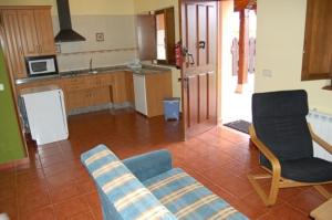 sala de estar con 2 sillas y cocina en Apartamentos Rurales La Regatina, en Lamuño