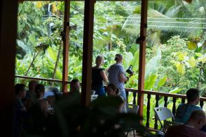 eine Gruppe von Menschen, die in einem Restaurant mit Blick auf den Wald stehen in der Unterkunft Ara Ambigua Lodge in Sarapiquí