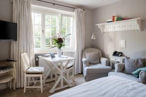 ein Schlafzimmer mit einem Tisch, Stühlen und einem Bett in der Unterkunft von Deska Townhouses - Ivy House in Hamburg