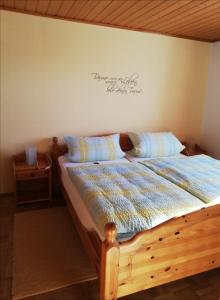 a bedroom with a bed with a sign on the wall at Ferienhof Jungkunz in Schwarzenbach am Wald