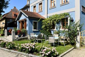 ein blaues Haus mit Stühlen und einem Tisch im Hof in der Unterkunft Hotel Bezold in Rothenburg ob der Tauber