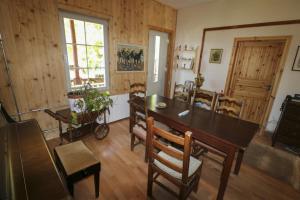 - une salle à manger avec une table et des chaises en bois dans l'établissement Riversong Centre Thermal, à Les Plans-sur-Bex