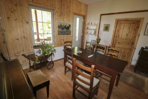 a dining room with a wooden table and chairs at Riversong Centre Thermal in Les Plans-sur-Bex
