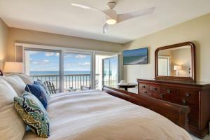 a bedroom with a bed with a dresser and a mirror at Amelia Island Oceanfront 2 Master Suites in Amelia Island