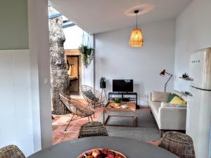 a living room with a table with a bowl of fruit at Beach Tree House in Porto Santo